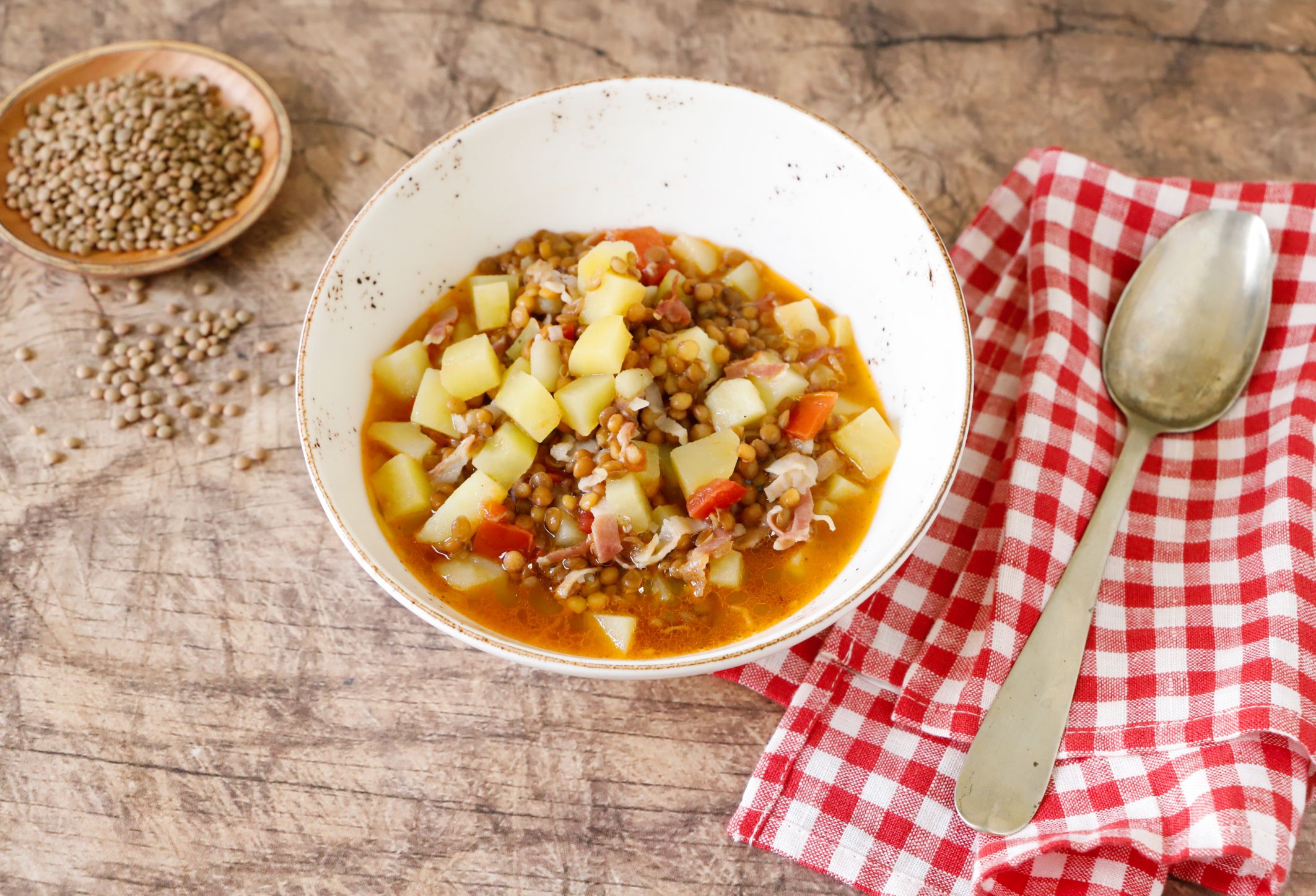 La minestra di lenticchie saporita con lardo, pomodoro e patate